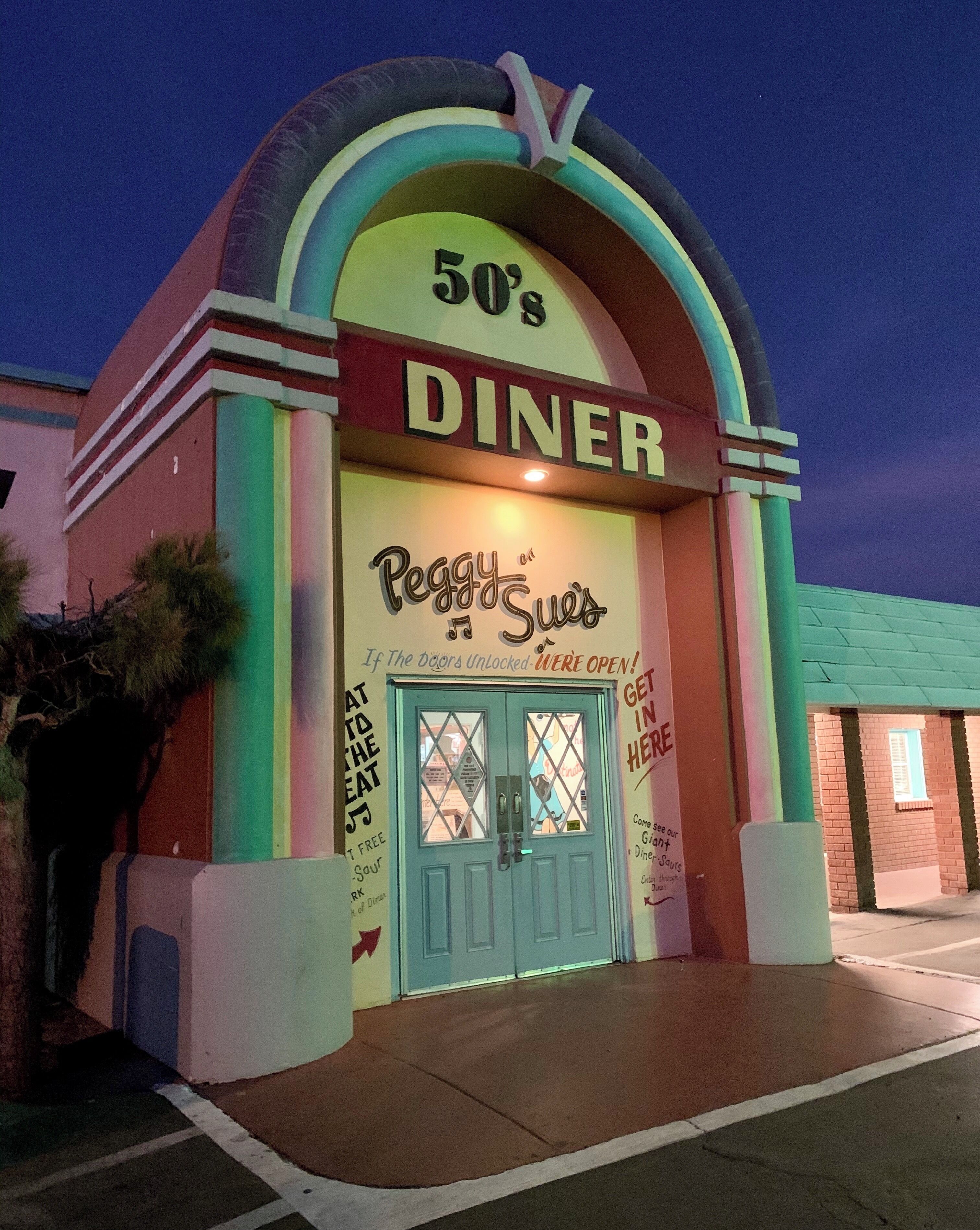 A diner with a colorful sign and a blue door.