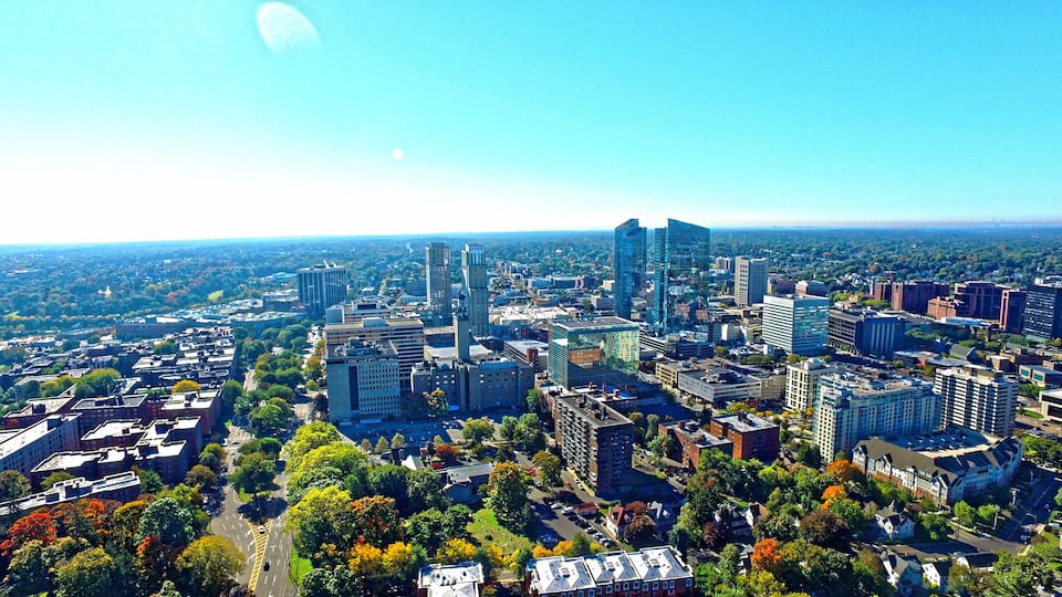 A cityscape with modern high-rise buildings, a mix of residential and commercial structures, and a dense urban layout.
