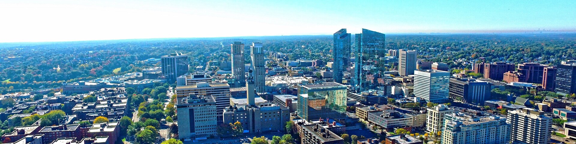 Paisagem urbana com edifícios modernos altos, uma combinação de estruturas residenciais e comerciais, e uma disposição urbana densa.