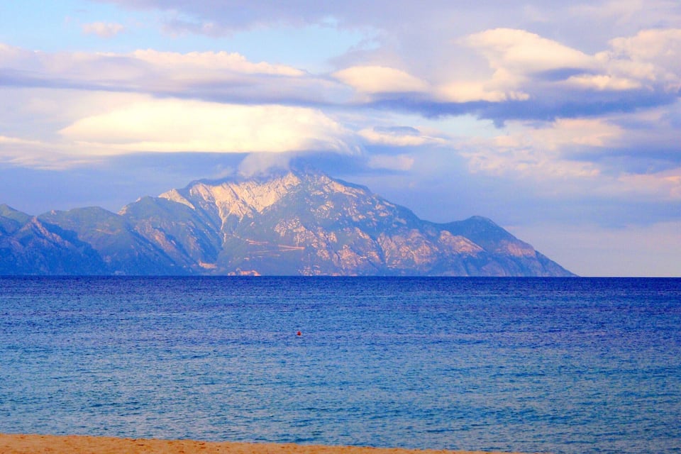 Une chaîne de montagnes avec une plage au premier plan.