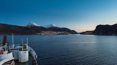 A boat docked at a harbor with a mountain range in the background.