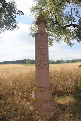 Denkmal für Gefallene des 3. Brandenburgischen Infanterie-Regiments No. 20 im Krieg von 1866. Runder Pfeiler mit achteckigem Sockel und Pickelhaube an der Spitze. Inschrift: DIE TAPFERN GEBLIEBENEN DES BRANDENBURGISCHEN INF. REGIMENTS No. 20. / 1866. / SECOND LIEUTNANT: / MAX KROHN AUS WERBEN BEI ZOSZEN. / DIE GEFREITEN: / JOHANN FRIDRICH KOHL AUS BARDEWITZ. / WILHELM GECK AUS ISERLOHN. / FRANZ HÜLLEN AUS BERLIN. / GOTTHELF LEITEL AUS MESERITZ. / DIE MUSKETIERE: / EDUARD SIEGNER AUS BEELITZ. / JOHANN GOTTLIEB MITTAG AUS BAERWALDE. / FRIDRICH WILHELM MÜLLER AUS DOBRILUCK. / JOHANN FRIDRICH FISCHBECK AUS EERCH. / GOTTFRID ALBERT HOHENSCHILT AUS SHLUNKENDORF. / EDMUND EMIL RUDOLPH FISCHER AUS BERLIN. / DIE FÜSILIERE: / PETER EICHELBAUM AUS NESCHHOLZ. / ERNST KUBAT AUS RATZEBUR. / CARL WILKE AUS BERLIN.