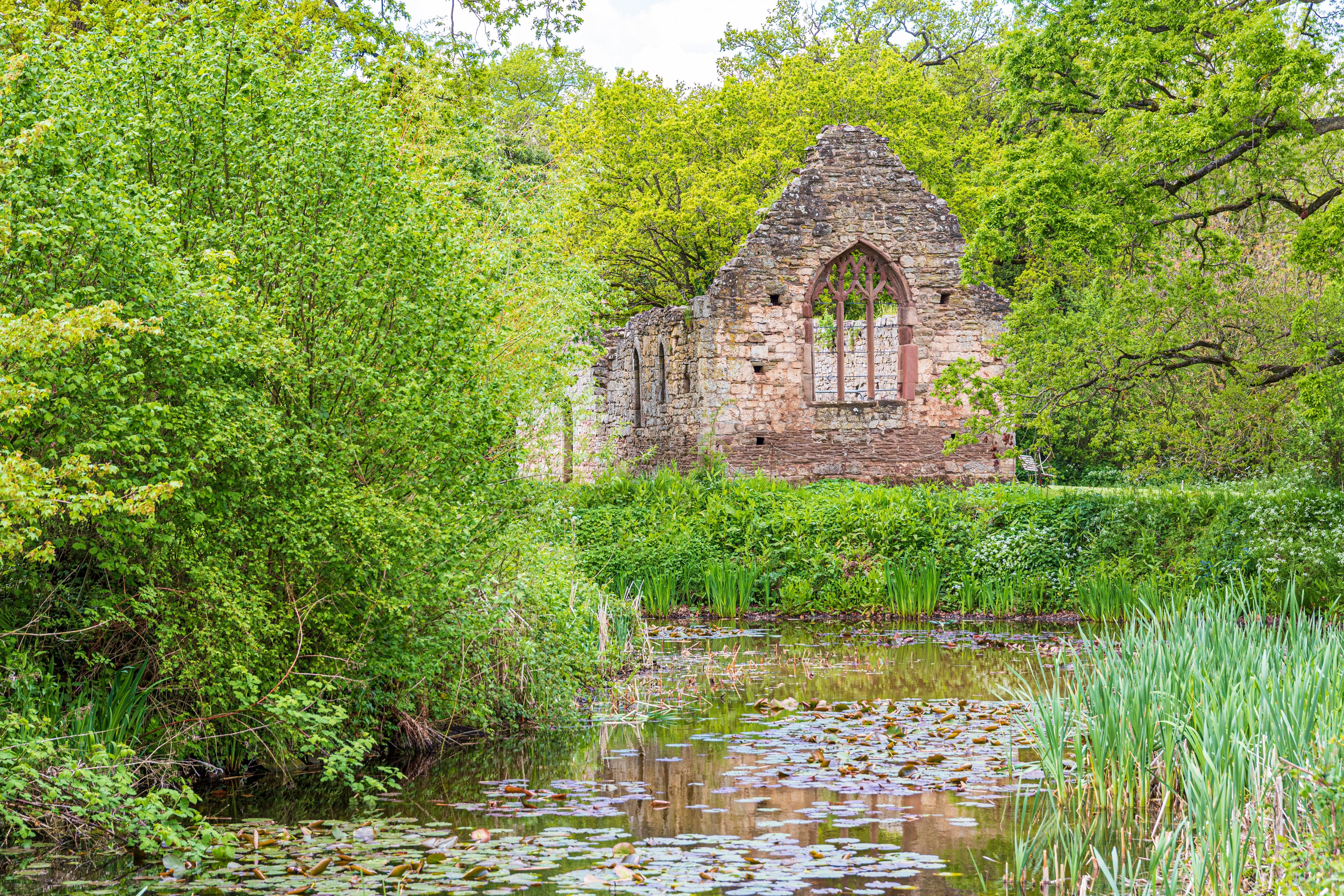 The ruins of the 12th century Norman chapel beside the moat of Lower Brockhampton Manor House near Bromyard, Herefordshire, England UK