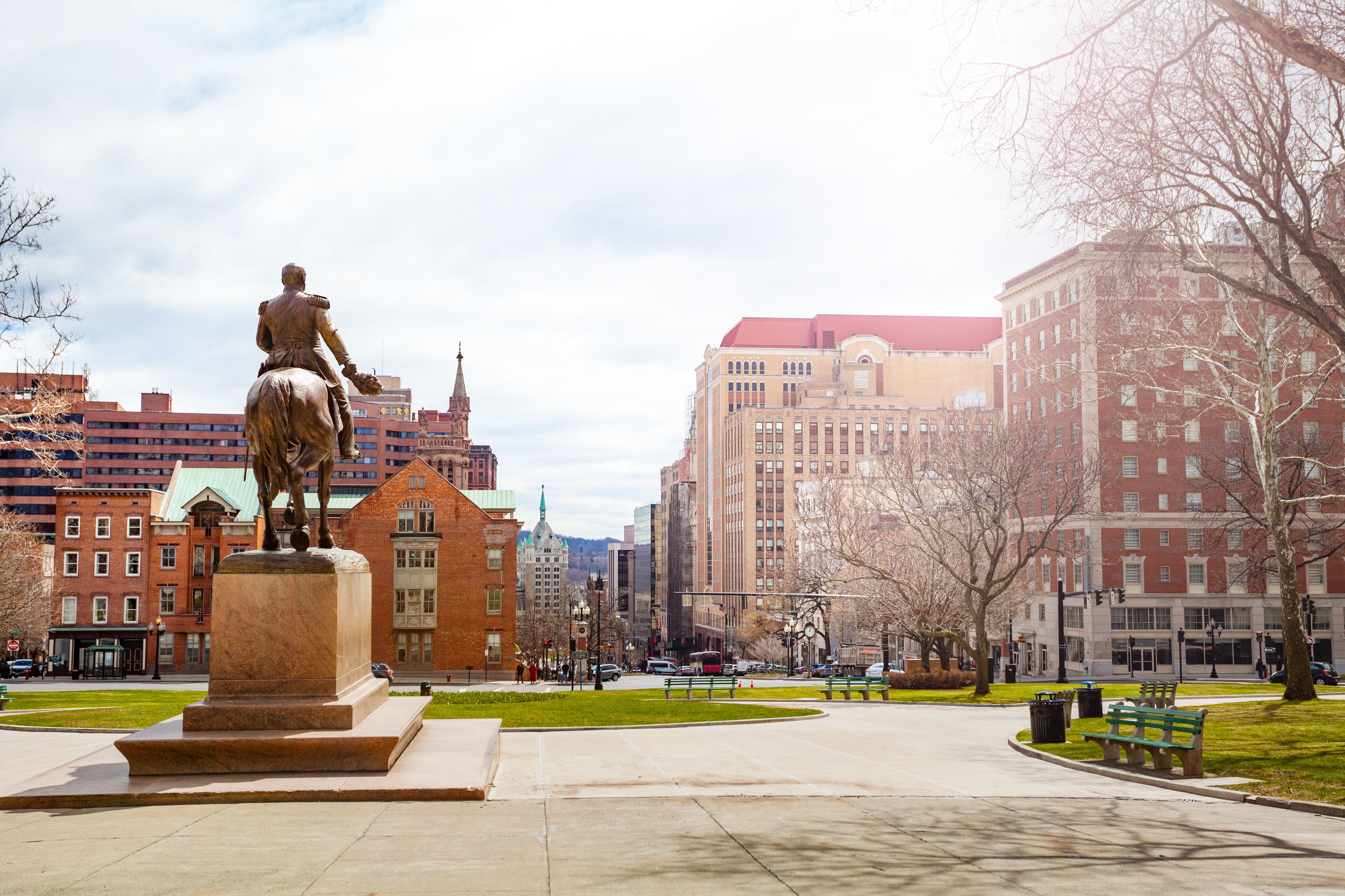 A statue of a man on horseback in a city square with buildings in the background.