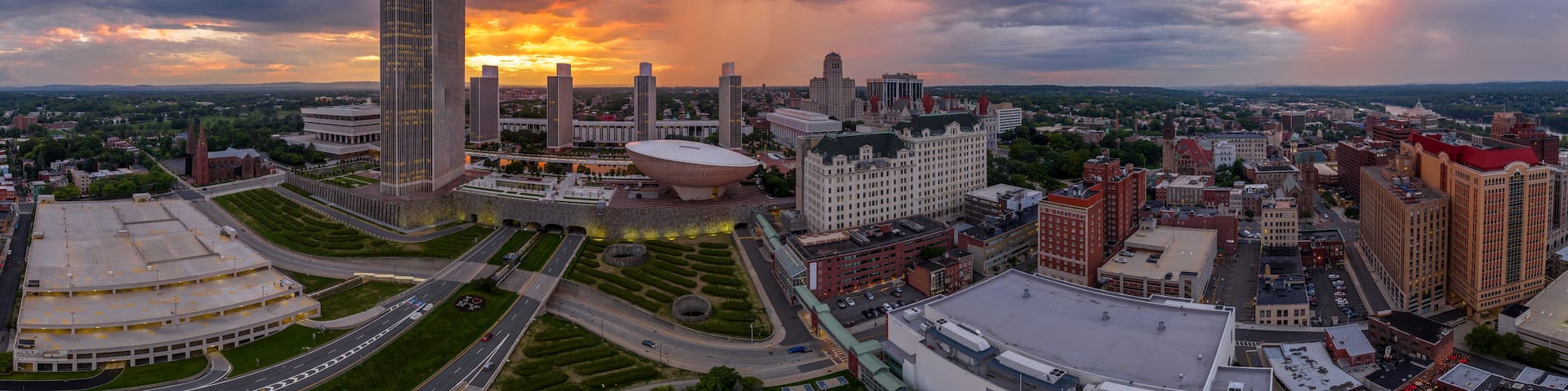 A cityscape with a large modern building, a dome-shaped structure, and a historic church.