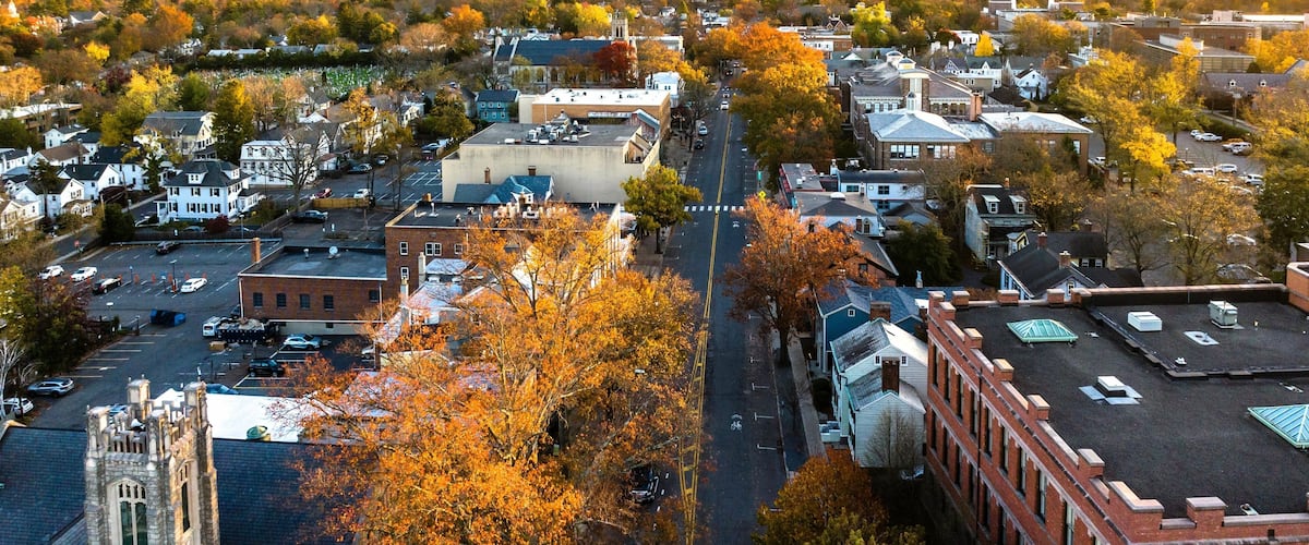 An aerial view of a town with autumn foliage, a prominent church, and a main street.
