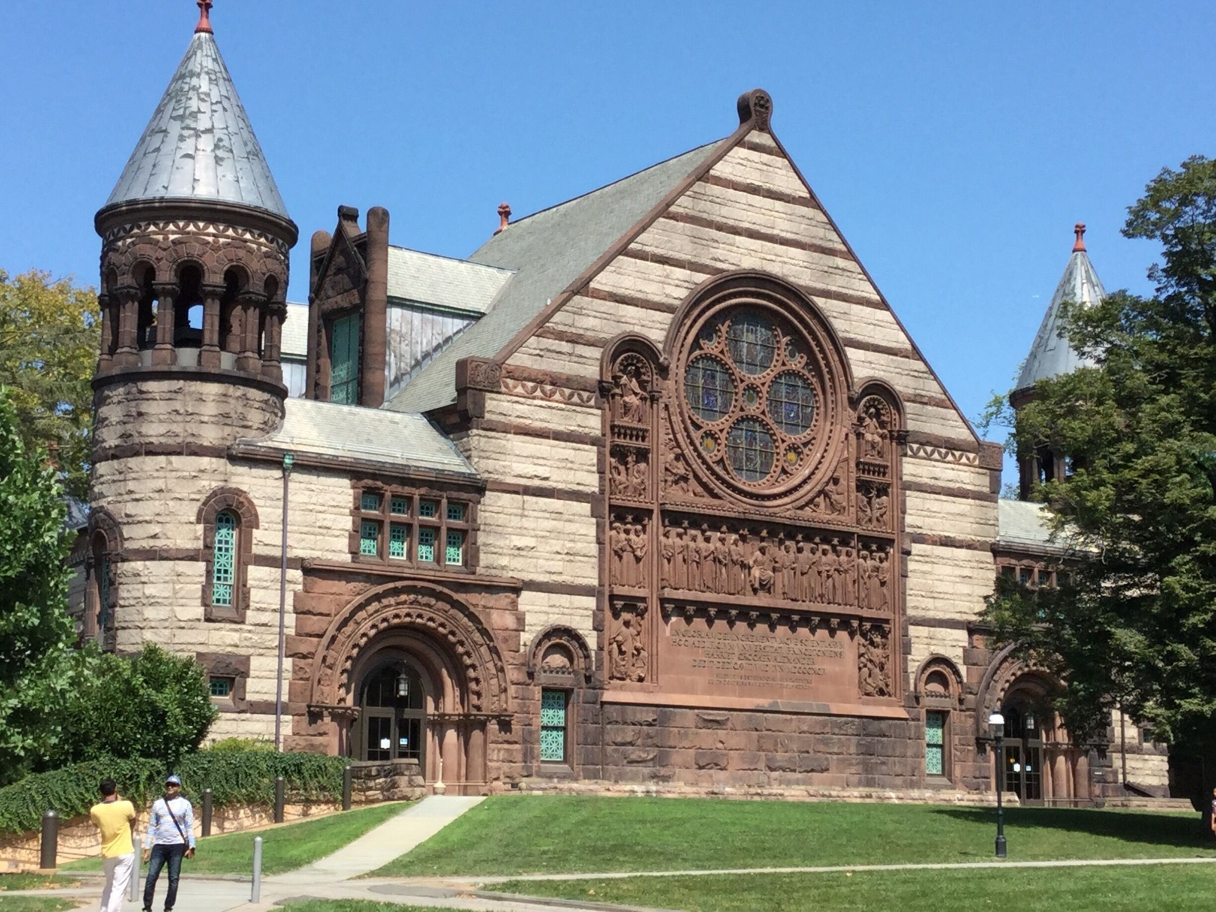 A historic building with a large arched window, stone towers, and intricate carvings.