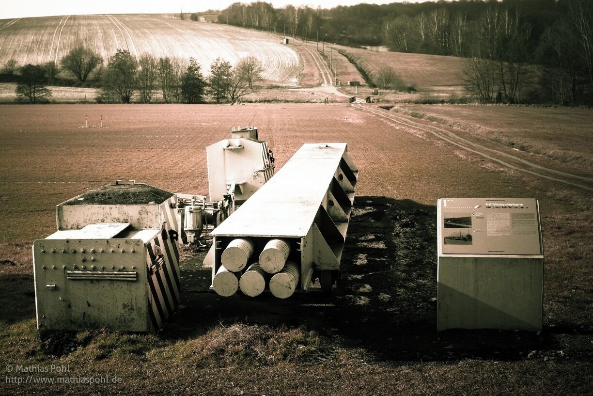 Part #3: Emergency Anti-Vehicle Barrier
Rolling barriers were set up on the East German side of almost every road border crossing. 11 m long and 6 t in weight, they were designed to prevent "border breakthroughs by vehicles". 
From a cabin above a Bunker, 2 border guards on duty could operate the barrier at the touch of a button. Triggered by a hydraulic punch, the Barrier then rolled into its counterpart within 3 seconds. The barrier could only be opened again using a cable winch. It was tested between 3am and 4am every day.