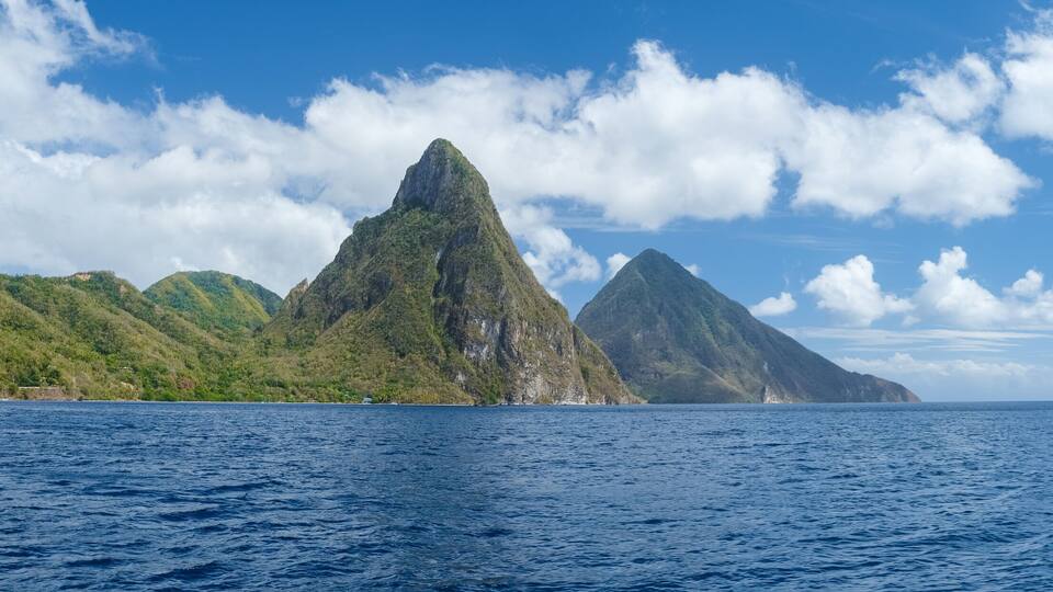 A mountainous landscape with a clear blue sky and calm sea.
