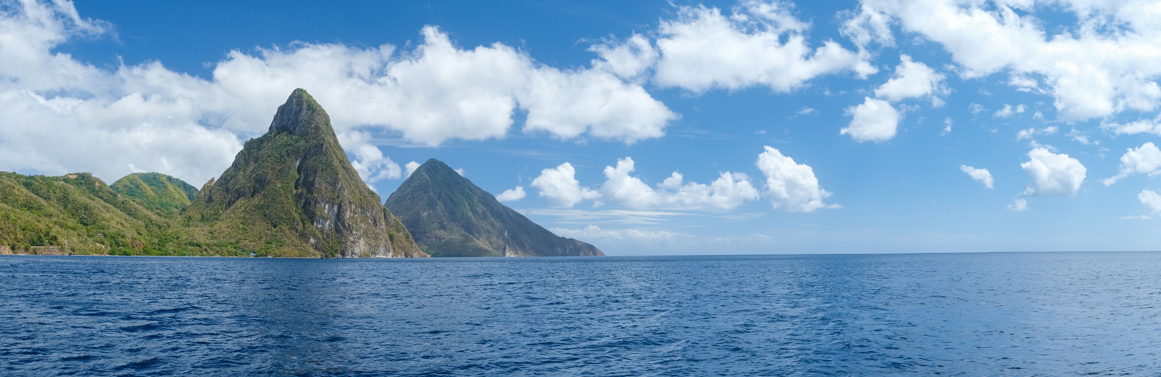A mountainous landscape with a clear blue sky and calm sea.