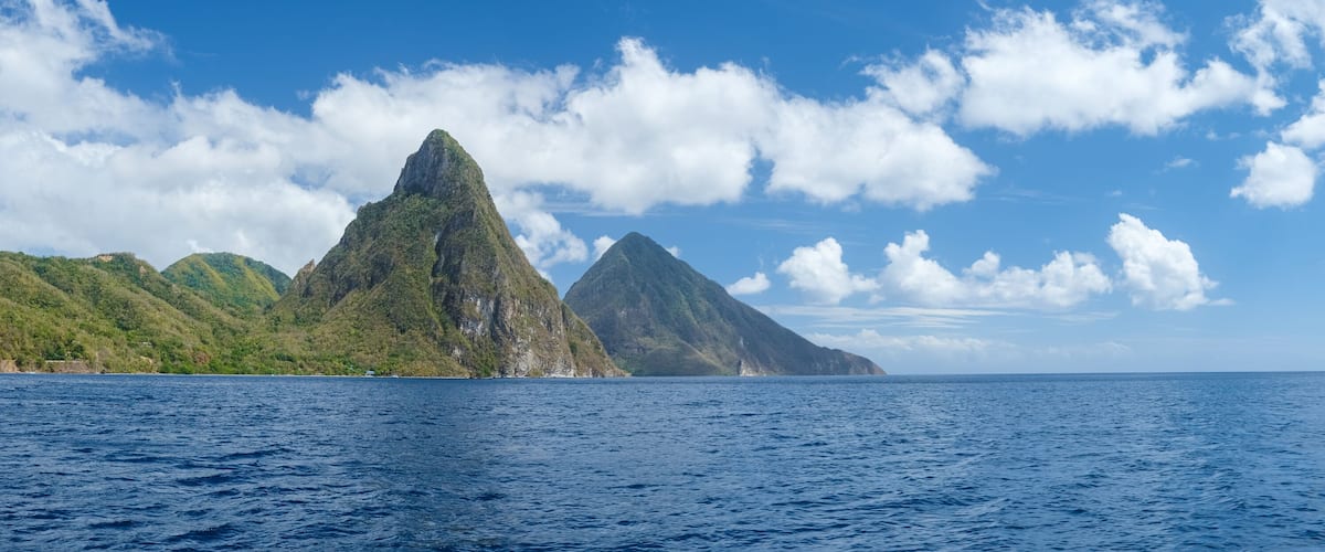 A mountainous landscape with a clear blue sky and calm sea.
