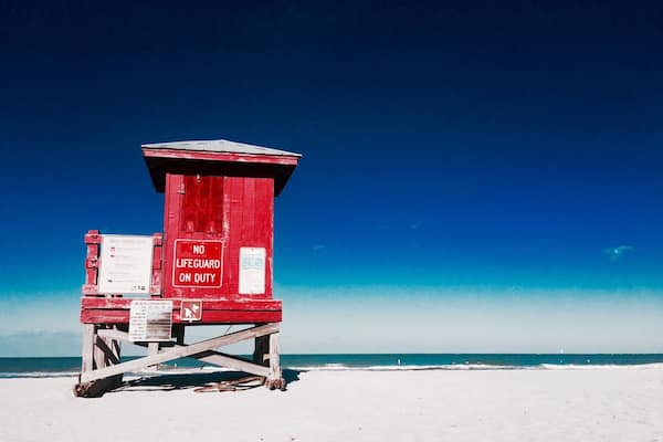 Et vagttårn for livreddere på en strand med en klar blå himmel.