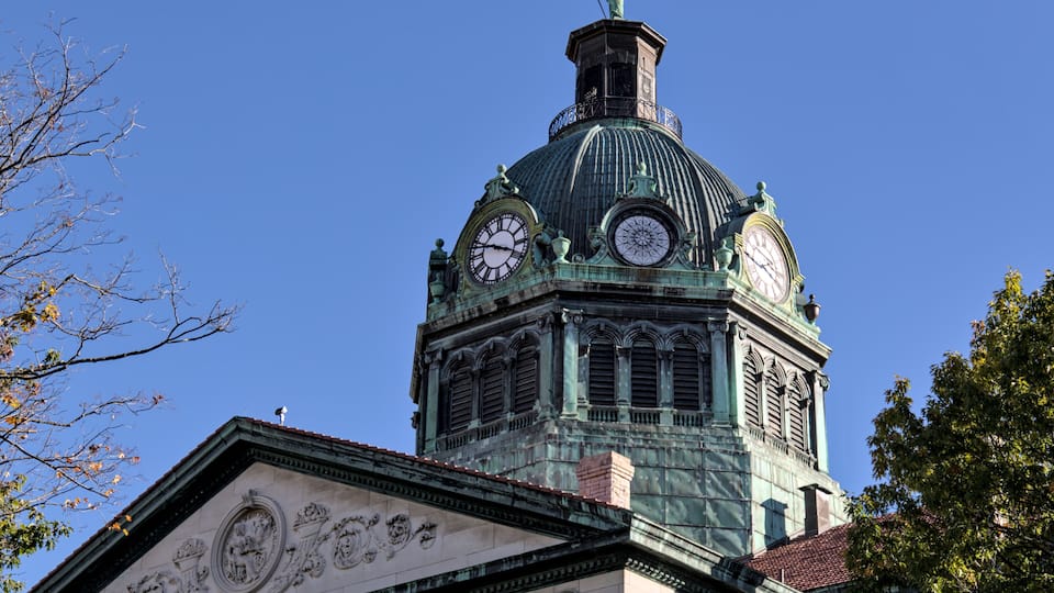 A building with a dome, a statue, and a clock.