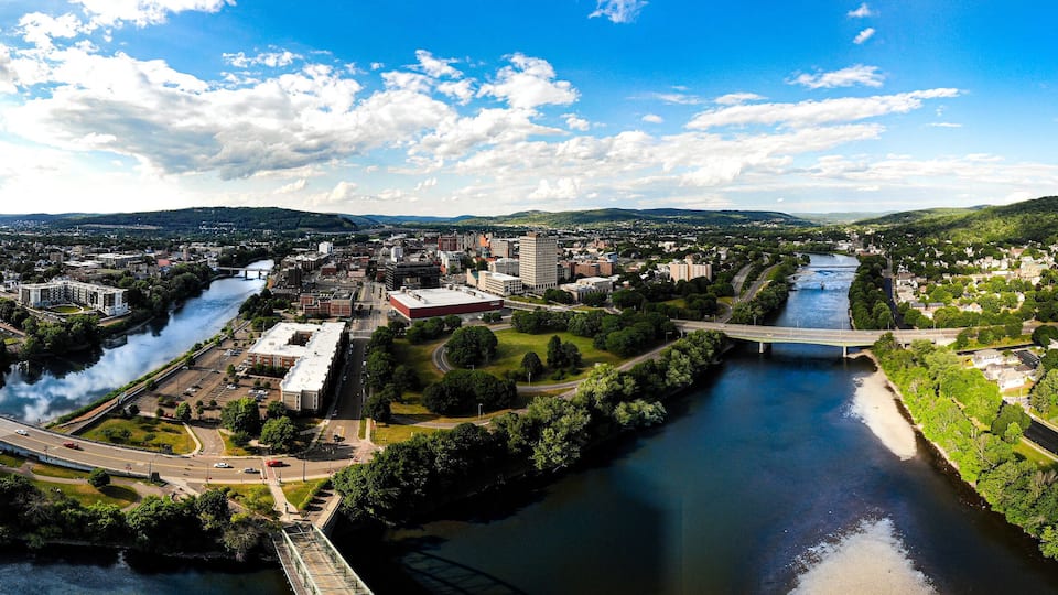 A river flowing through a city with bridges, buildings, and green areas.