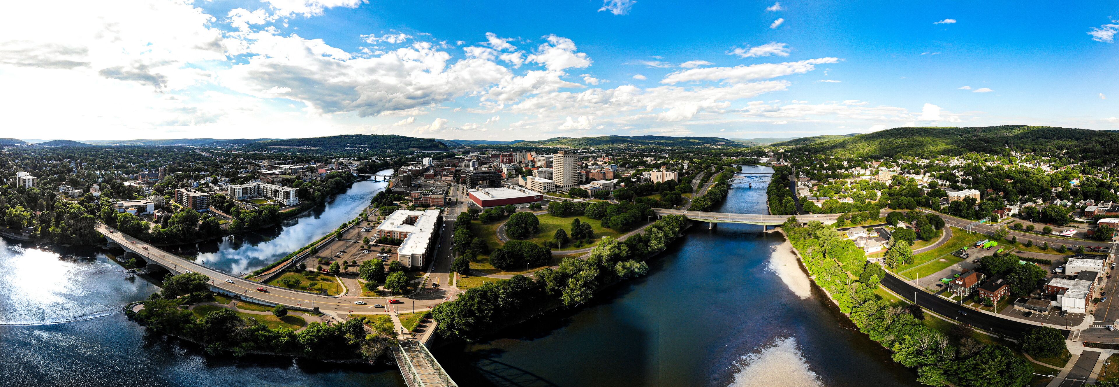 A river flowing through a city with bridges, buildings, and green areas.