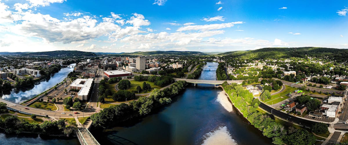 A river flowing through a city with bridges, buildings, and green areas.