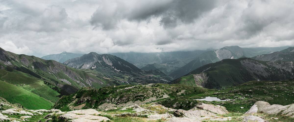 A mountainous landscape with rocky terrain and patches of green vegetation.