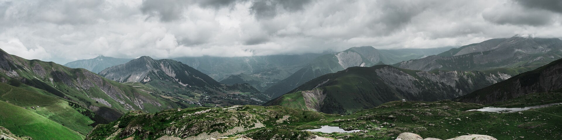 A mountainous landscape with rocky terrain and patches of green vegetation.