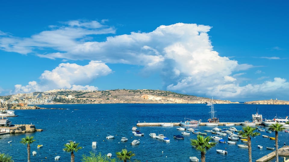 Panorama of shoreline and embankment. Boats moored in harbour. Bugibba. Saint Paul's Bay. Malta