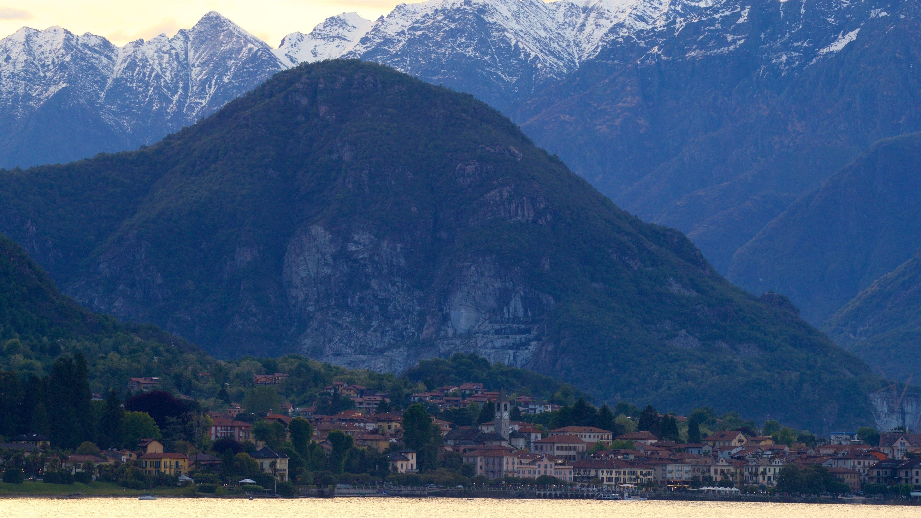 A town by a lake with mountains in the background.