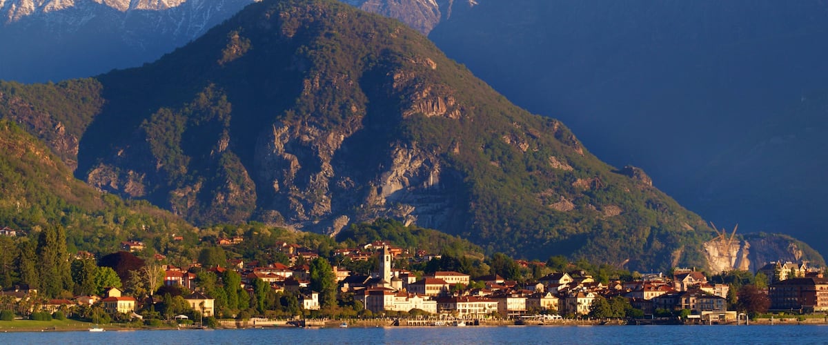 A lakeside town with a mountain backdrop.