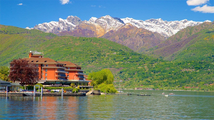 Un edificio junto al lago, con montañas al fondo.