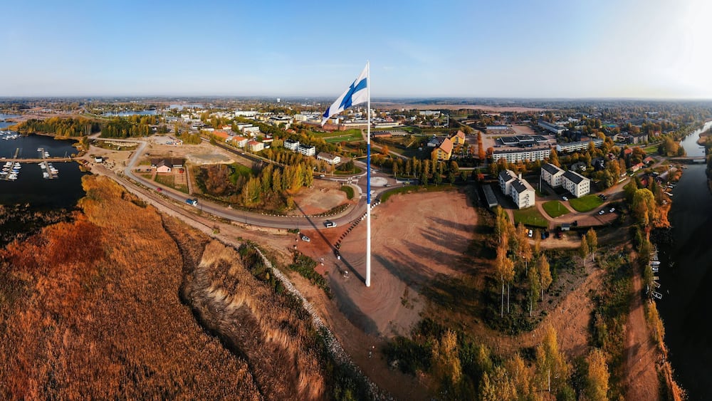 Aerial panoramic view of the largest finnish flag in the world and the tallest flagpole in Europe against of Hamina city, Finland. The flag pole is 100 meter high.