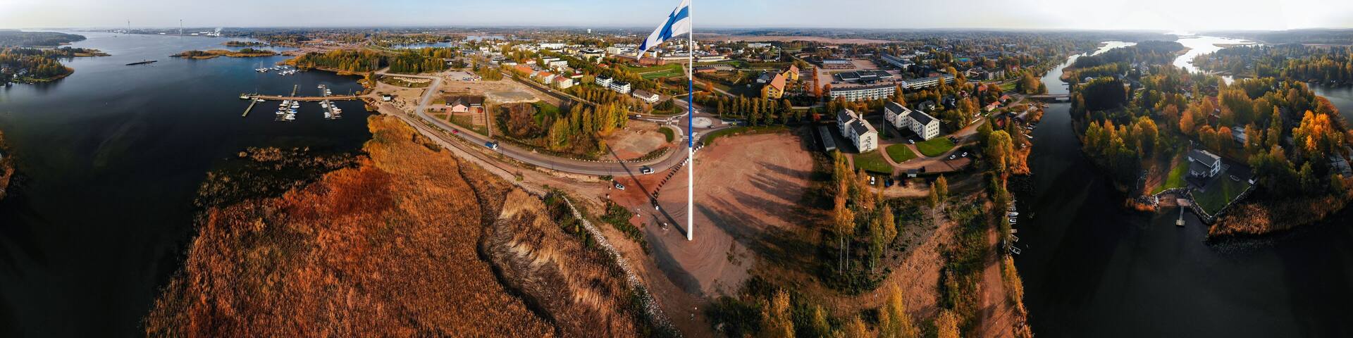Aerial panoramic view of the largest finnish flag in the world and the tallest flagpole in Europe against of Hamina city, Finland. The flag pole is 100 meter high.
