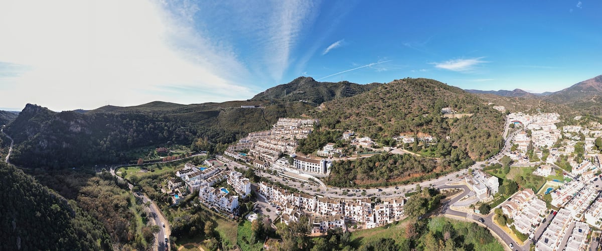 Panorama aerial of mountain range with Benahavis village luxury housing along the sun coast