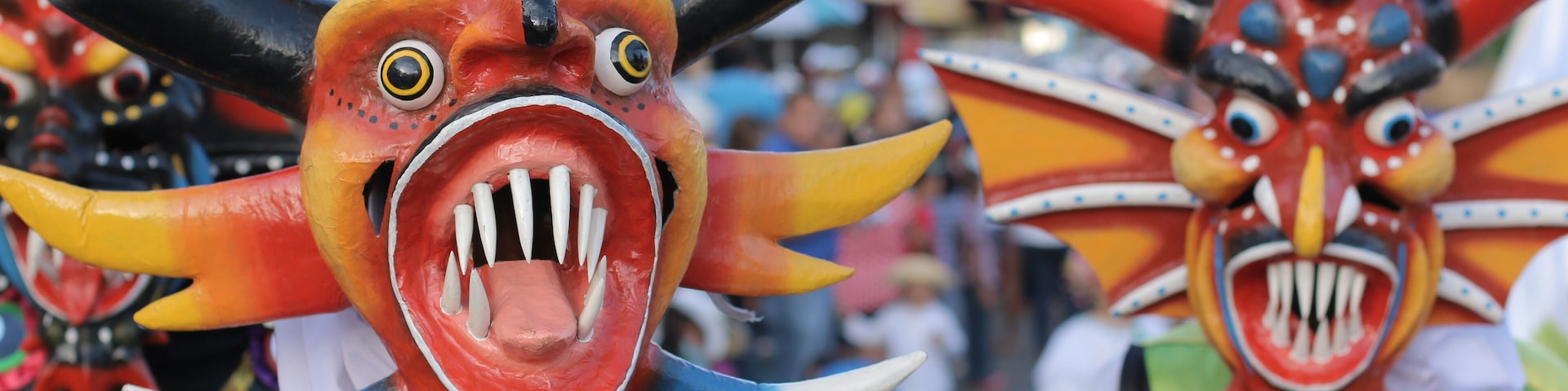 Máscaras coloridas com chifres e dentes.