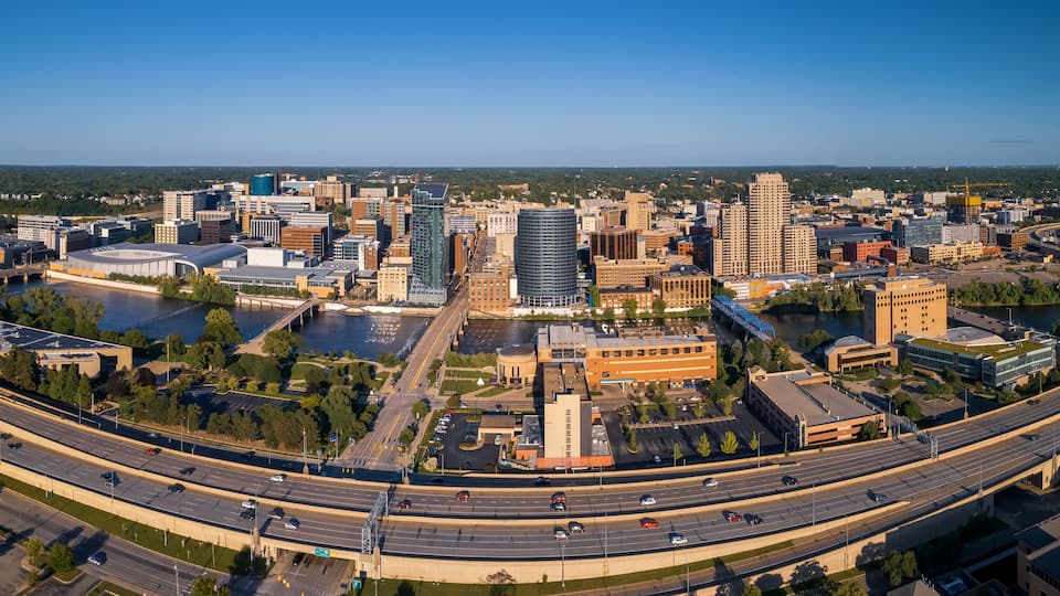 A cityscape with a river, a bridge, and a highway.