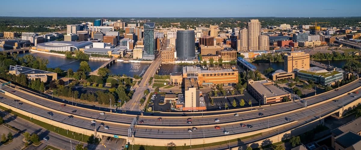 A cityscape with a river, a bridge, and a highway.