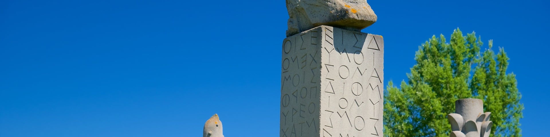 A stone monument with inscriptions and a carved head at the top.