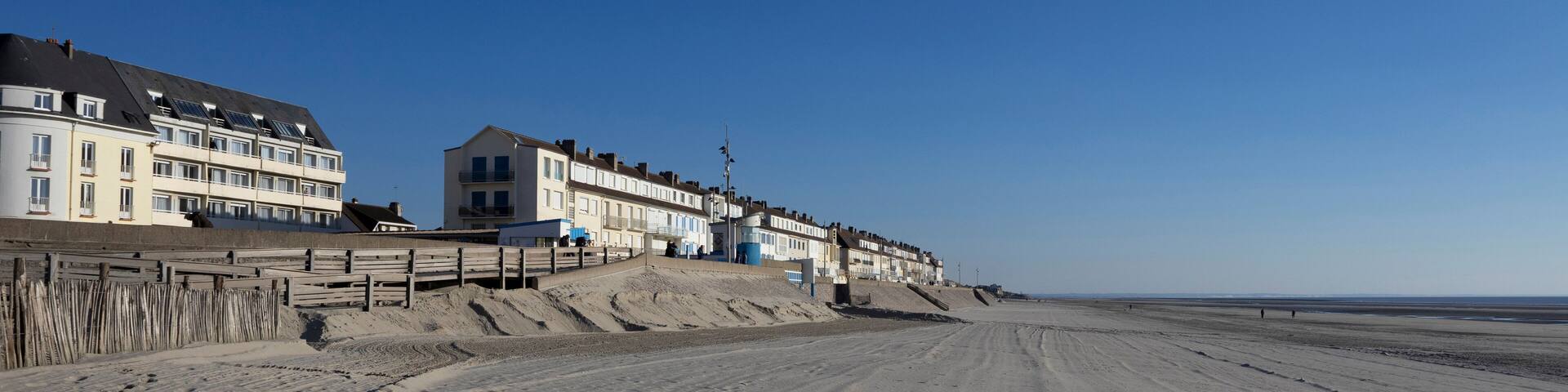 View of the beach and seafront at Fort-Mahon-Plage in the Somme department of Hauts-de-France in Northern France. Beautiful sunny spring evening with clear blue sky. Copy space above.