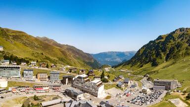 Uma cidade montanhosa com edifícios, estradas e um estacionamento.