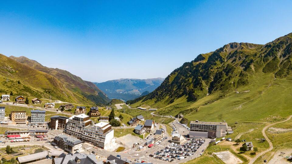 A mountainous town with buildings, roads, and a parking lot.