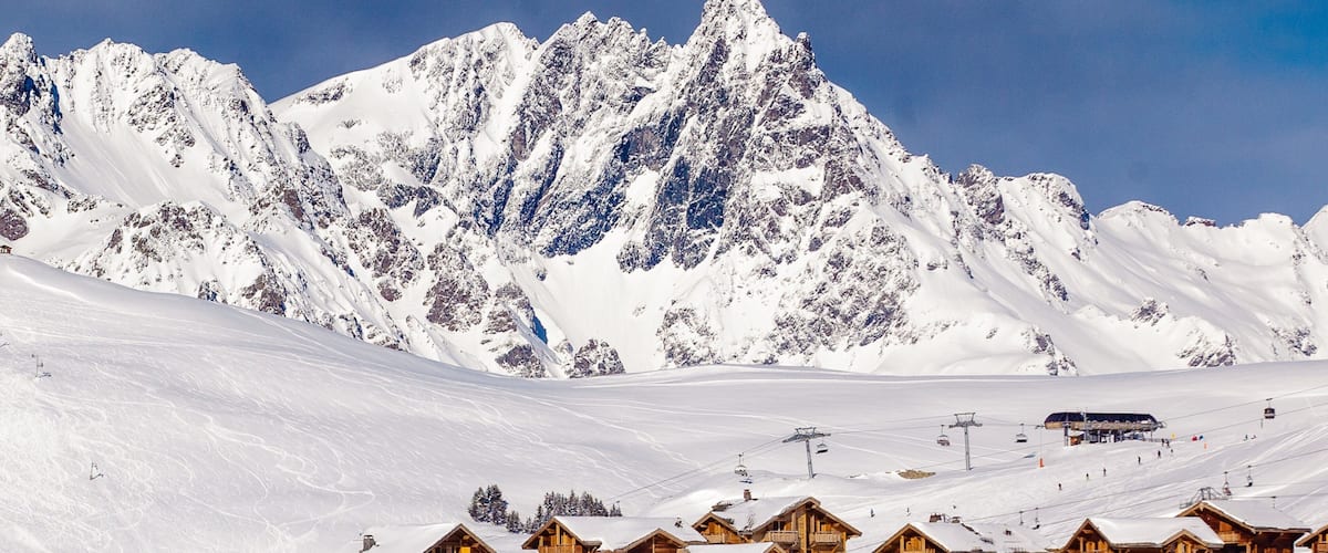 l\'Alpe-d\'Huez joka esittää vuoret, pieni kaupunki tai kylä ja lunta