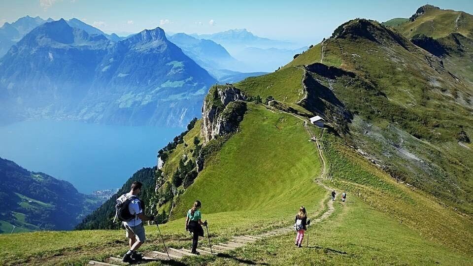 A mountainous landscape with hikers on a trail.