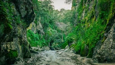 Mountain gorge with caves and little river from the portuguese touristic site of Olhos de Agua - Alviela - Alcanena