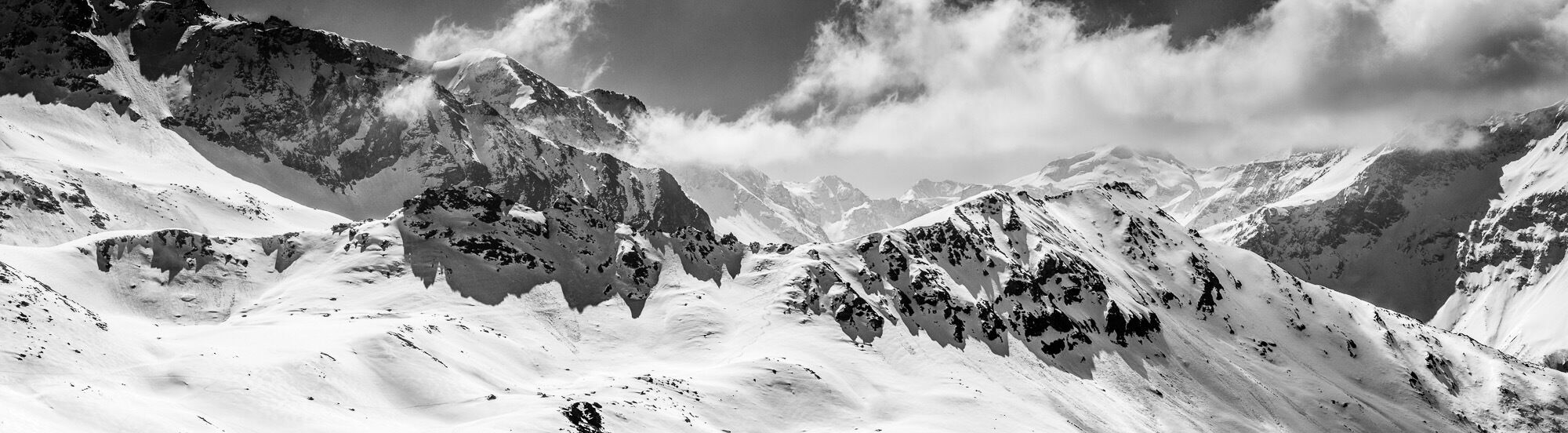 A snow-covered mountain range with rugged peaks and valleys.