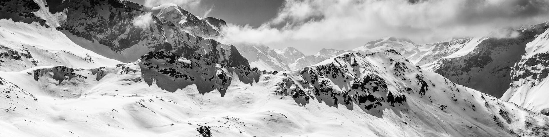 A snow-covered mountain range with rugged peaks and valleys.