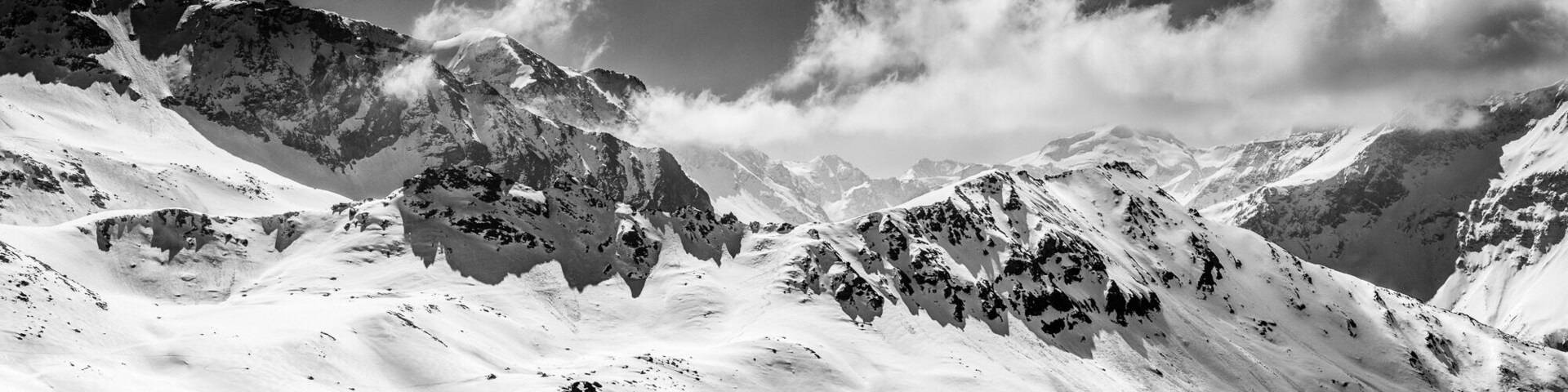 Uma cordilheira coberta de neve com picos e vales acidentados.