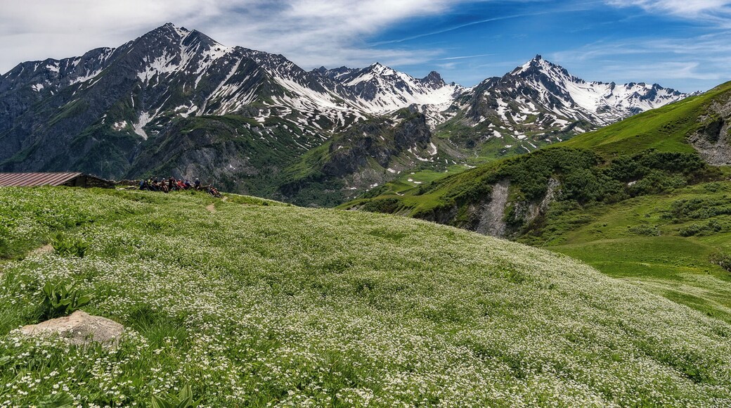 Hikers pause for a break during the long descent to Les Chapieux on the Tour du Mont Blanc. This image captures a lot of what makes the TMB special. Dramatic peaks, fields of green, blankets of wildflowers, and enjoying it all with other hikers from around the world.