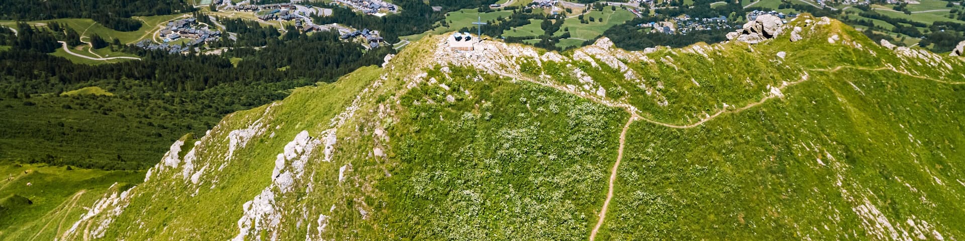 Panoramic drone view of the mountain peak called Creve-Tete in the french Alps with the village of Valmorel on the background France