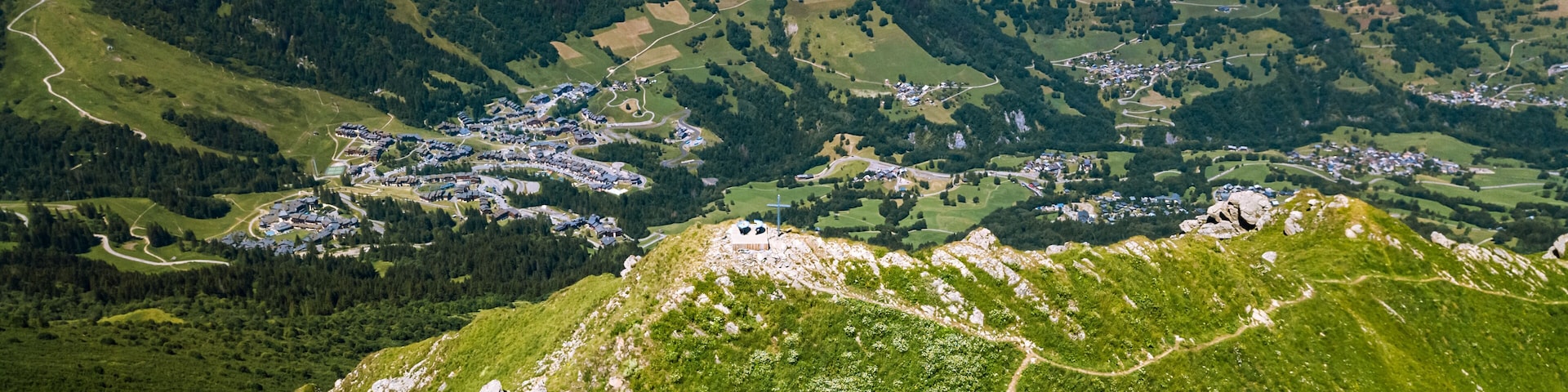 Panoramic drone view of the mountain peak called Creve-Tete in the french Alps with the village of Valmorel on the background France