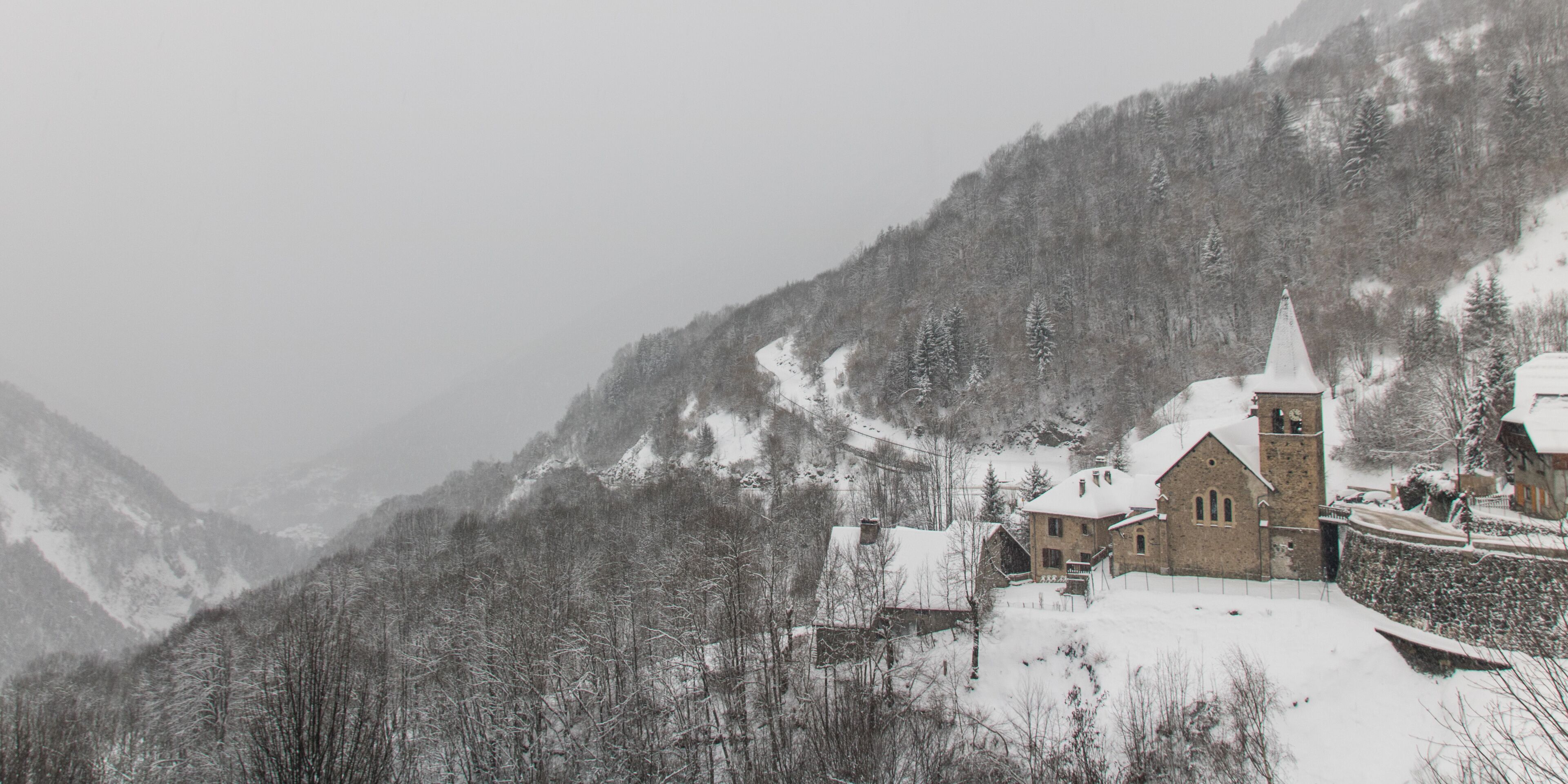 village ancien de Vaujany en hiver sous un ciel gris neigeux
