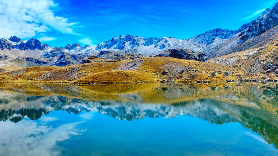 A mountain range with a clear lake reflecting the peaks.