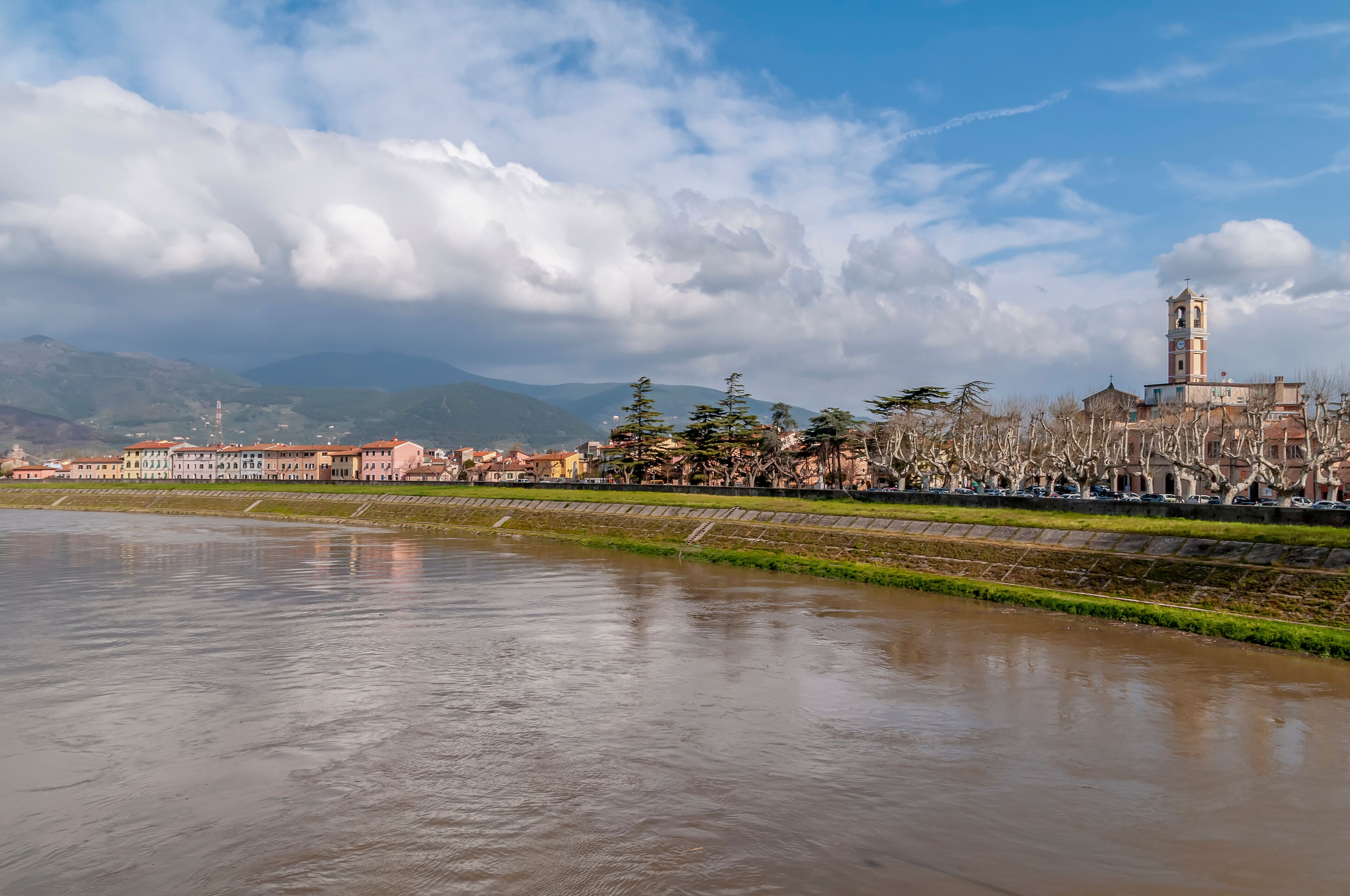 A river with buildings and a tower in the background.