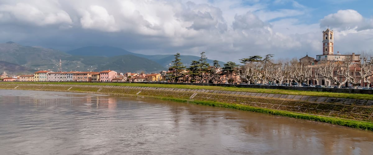 A river with buildings and a tower in the background.