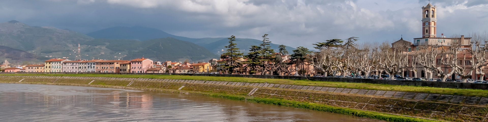 A river with buildings and a tower in the background.